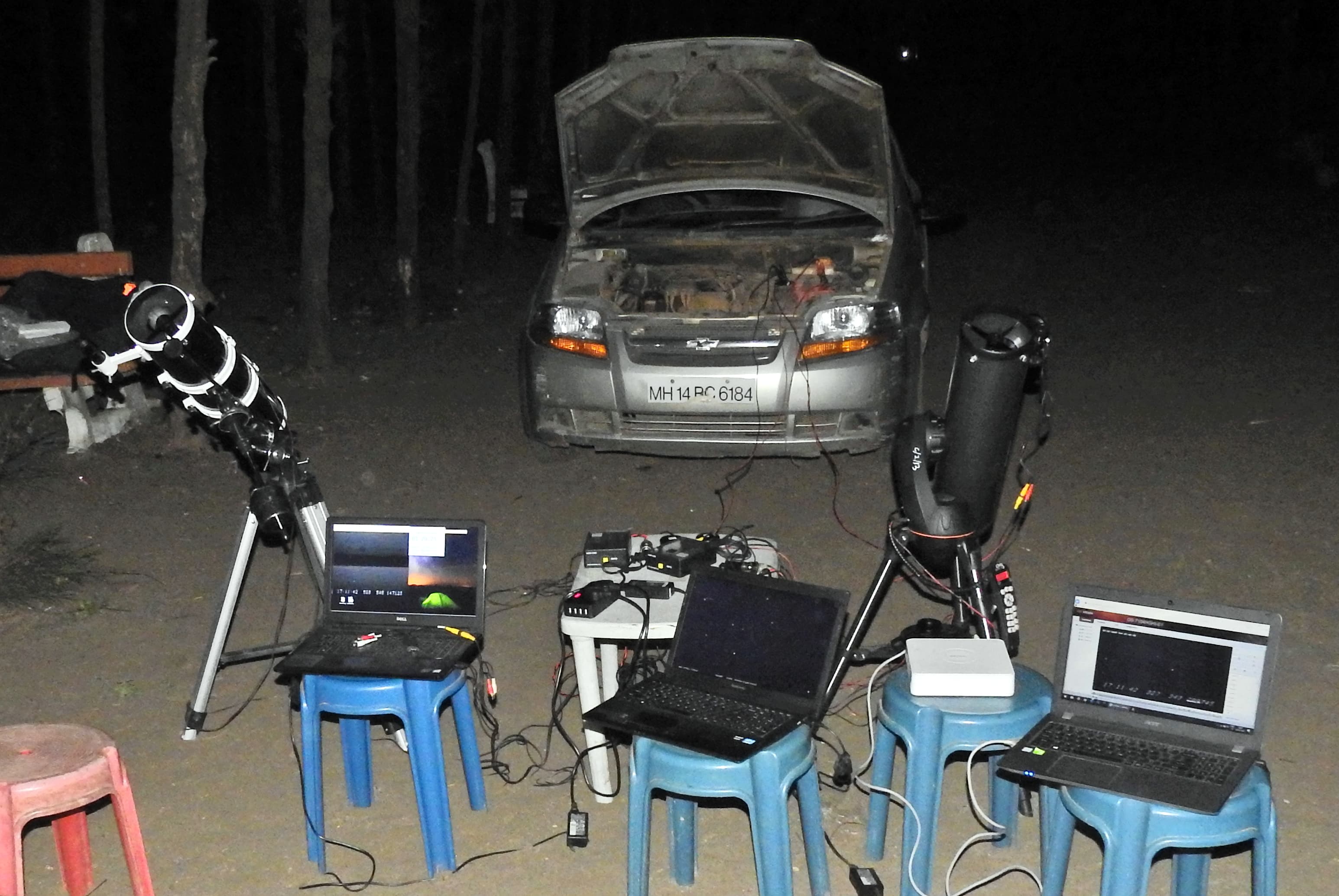 Telescopes, cameras, power equipment and laptops arranged outdoors